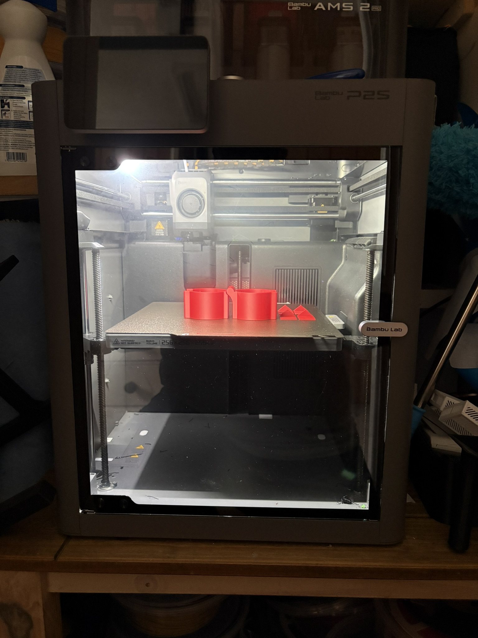 Bambu Lab P2S Combo 3D printer with AMS 2 Pro, mid-print with the door open